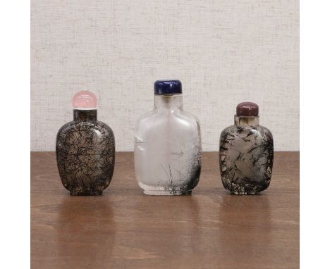 Three Chinese tourmalinated-quartz snuff bottles, Qing dynasty (1644-1911), each of compressed elongated form, the stone dens