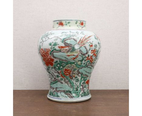 A Chinese wucai vase, Kangxi (1662-1722), of baluster form, painted with a pheasant standing on a pierced rock amongst magnol