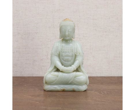 A Chinese jade Buddha, 20th century, wearing a long robe and beaded jewellery, seated cross-legged with both of his hands res