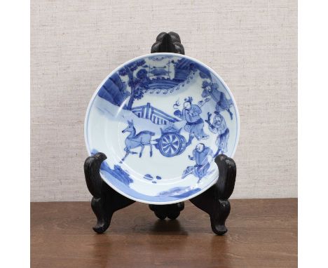 A Chinese blue and white saucer, Kangxi (1662-1722), the rounded sides rising from a circular foot to a flared rim, painted w