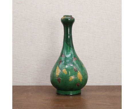 A Chinese famille verte vase, Kangxi (1662-1722), the pear-shaped body rising from a circular foot to a garlic mouth, painted