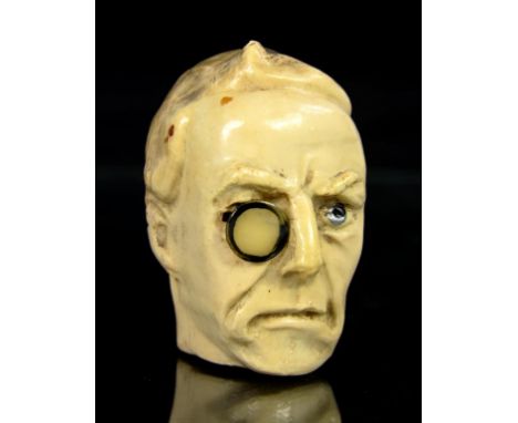NEEDLEWORK TOOLS.  AN UNUSUAL EARLY 20TH CENTURY CELLULOID TAPE MEASURE IN THE FORM OF THE HEAD OF JOSEPH CHAMBERLAIN, 5CM H