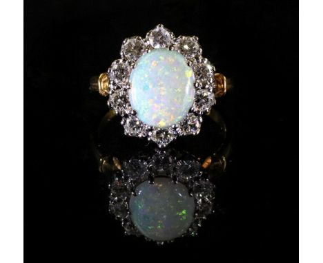 A gold, opal and diamond cluster ring, mounted with the oval opal at the centre, in a surround of ten round diamonds, to gold