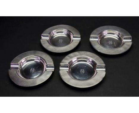 A set of four circular engine turned silver ashtrays, makers marks T &amp; S, Birmingham 1938, 11.5cm diameter, 10ozs, monogr