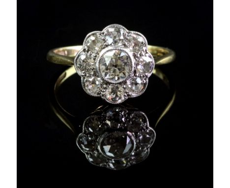 A gold and diamond cluster ring, mounted with the principle old cut diamond at the centre, weighing approximately 0.45cts, in