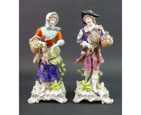 A pair of continental porcelain figures, one modelled as a young man in a floral coat, holding a basket of flowers and a bird