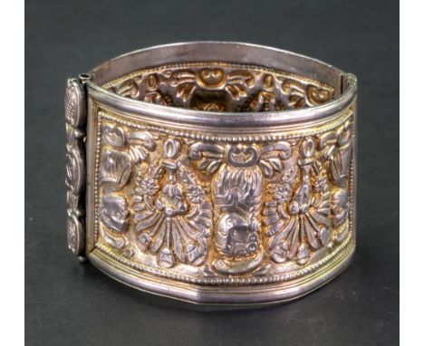 A silver gilt cuff bangle, decorated with figural and floral motifs, 47mm wide, 64.90g gross. 