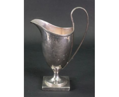 A George III silver helmet shape cream jug, probably John Robins, circa 1790, with threaded rim and scroll handle, on a squar