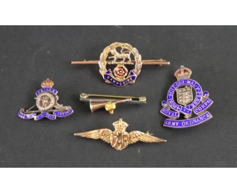 A collection of mostly military badges, including a gold RAF winged badge, a silver and enamel Army Ordnance badge, a gold wr