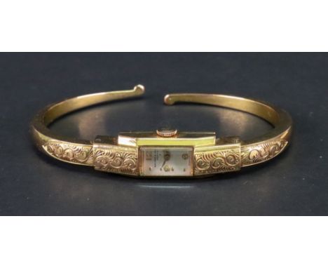 Baume &amp; Mercier, Geneve; a lady's gold plated bangle wristwatch, the dial with Arabic numerals and dot markers, the case 