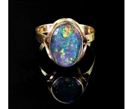 A gold and opal ring, the oval opal rubover set to gold band, ring size T, 3.15g gross. 