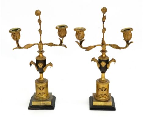 A pair of Empire style gilt metal and bronze twin light candleabrum, late 19th century, the leaf scroll branches supporting f