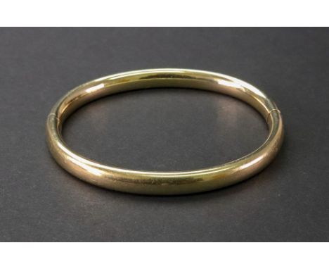 A gold oval hinged bangle, 23.02g gross. 