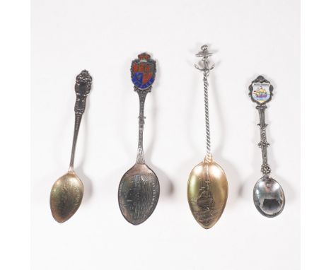 A collection of four vintage souvenir spoons, three of which are marked sterling silver. Each spoon features unique designs, 
