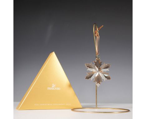 This Swarovski SCS Christmas Ornament from 2014 features a beautifully crafted golden shadow crystal snowflake with intricate