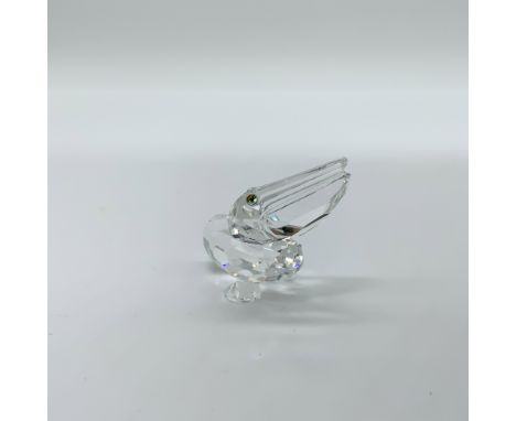 This retired Swarovski Crystal Pelican Figurine, part of the renowned "Feathered Friends" collection, is a stunning piece des