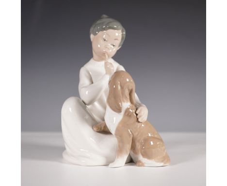 Lladro porcelain figurine titled Boy with Dog, model number 01004522. This charming piece features a young boy seated with a 