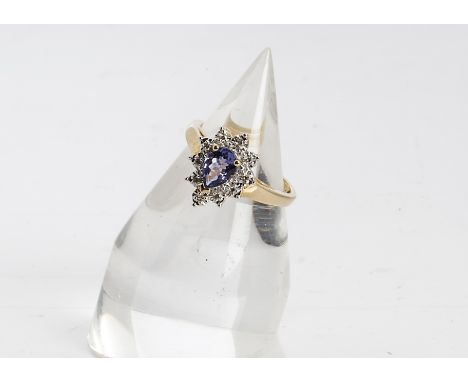 A tanzanite and diamond cluster ring, the central pear cut tanzanite within an illusion set diamond surround, set in white me
