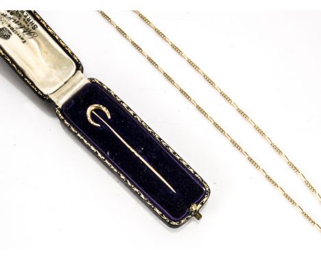 An Edwardian 15ct gold horseshoe stick pin, in velvet case together with a 9ct gold curb linked chain, total weight 4.3g 