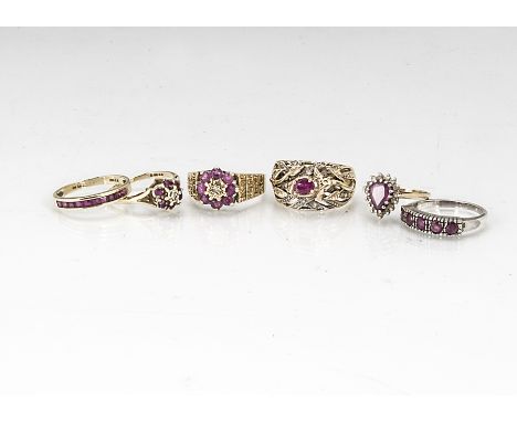 Six gold and ruby set dress rings, including a heart shaped ruby cluster ring, a circular diamond and ruby cluster ring in 9c