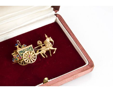 A continental gold, enamel and gem set brooch, modelled as a horse and carriage, the decorated horse pulling a green enamelle