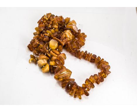 A string of graduated rough Baltic amber stones, the translucent beads culminating in a large boulder with internal sun spang