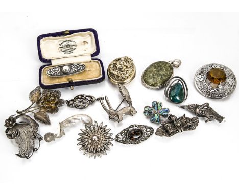 A collection of silver brooches and lockets, including an art nouveau cased rectangular brooch, an Indian locket, various fil