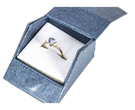 A 9ct gold tanzanite and diamond three stone ring, the trillion cut tanzanite flanked by two brilliant cut diamonds on yellow