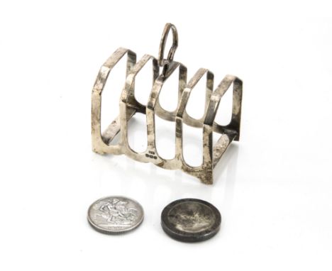 An Art Deco period silver toast rack by EV, together with a 1797 cartwheel two penny, VF-EF, and an 1889 crown, VF (3) 