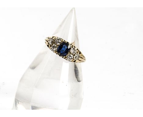 An Edwardian sapphire and diamond gold ring, the oval mixed cut sapphire in claw setting flanked by old cut claw set diamonds