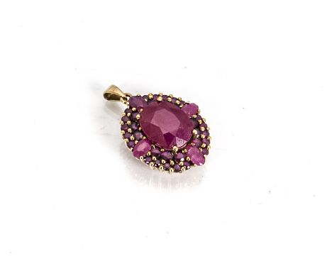 An 9ct gold oval ruby set pendant, the central oval ruby in four claw setting surrounded by two rows of circular cut rubies a