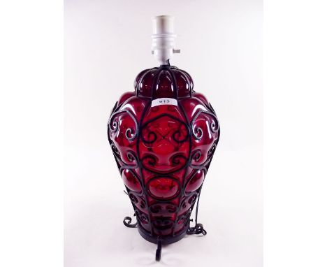 A Hundi style early 20th century ruby blown glass metal bound table lamp and shade