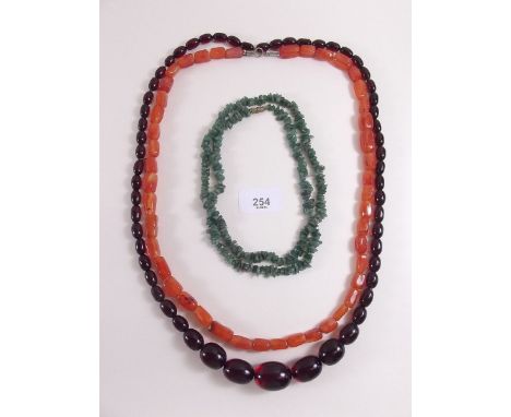 A string of orange stone beads, a 'jade' necklace and similar amber necklace 