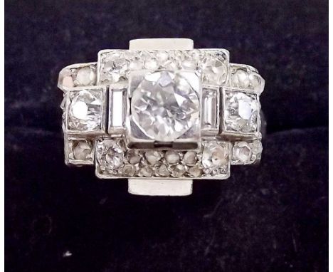 A French Art Deco platinum ring set central diamond (approx. 1/2 carat) within diamond set stepped surround