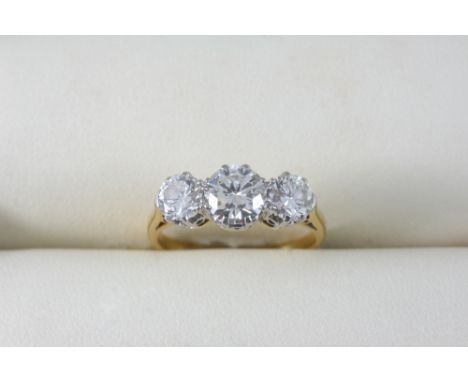 A DIAMOND THREE STONE RING set with three graduated brilliant-cut diamonds, in 18ct. gold and platinum. Size M.