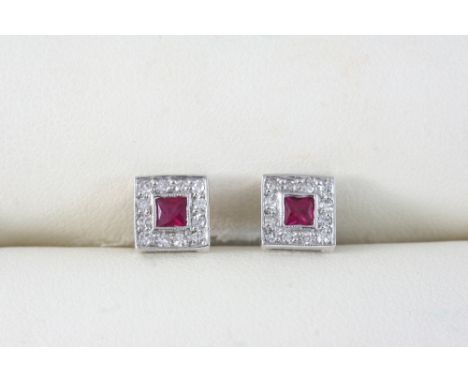 A PAIR OF RUBY AND DIAMOND CLUSTER STUD EARRINGS each set with a square-shaped ruby within a surround of circular-cut diamond