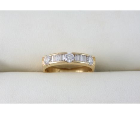 A DIAMOND HALF HOOP RING set with three circular-cut diamonds and six baguette-cut diamonds, in gold. Size L.