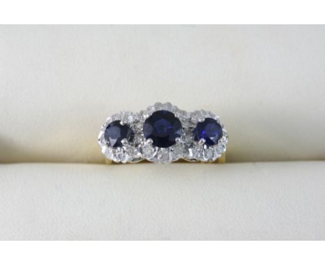 A SAPPHIRE AND DIAMOND TRIPLE CLUSTER RING set with three graduated circular-cut sapphires and with circular-cut diamonds, in