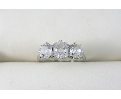 A DIAMOND THREE STONE RING set with three graduated cushion-shaped diamonds. Size Q 1/2. Provenance: The Hon. Lady Russell (1