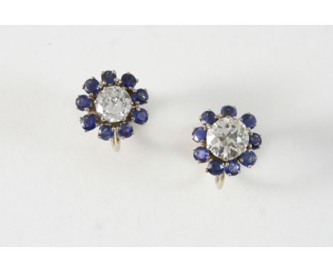 A PAIR OF DIAMOND AND SAPPHIRE CLUSTER EARRINGS each set with a circular-cut diamond within a surround of circular-cut sapphi