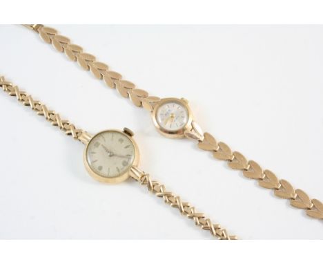 A LADY'S 9CT. GOLD WRISTWATCH BY AVIA the circular dial with two Arabic and with baton numerals, on a gold foliate integrated