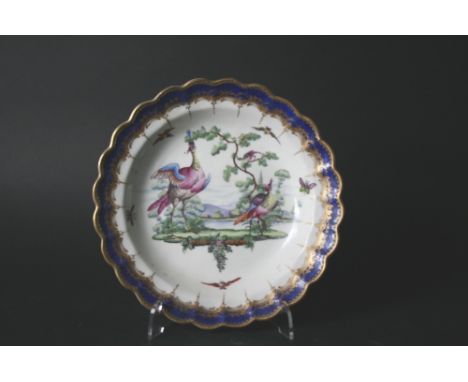 18THC WORCESTER PLATE with a shaped rim and boldly painted with exotic fancy birds and insects in a river landscape, with a b