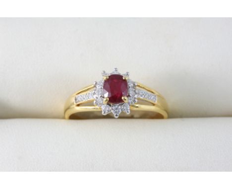 A RUBY AND DIAMOND CLUSTER RING the oval-shaped ruby is set within a surround of circular-cut diamonds, in 18ct. gold. Size W