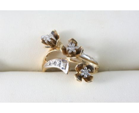 A DIAMOND AND GOLD RING of triple flower head form, set with small diamonds. Size O.