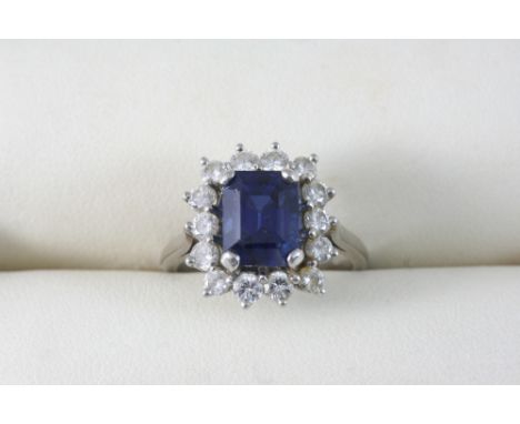 A SAPPHIRE AND DIAMOND CLUSTER RING the rectangular-shaped sapphire is set within a surround of circular-cut diamonds, in whi