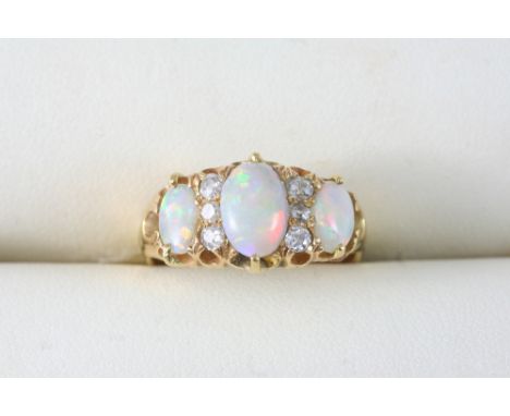 AN OPAL AND DIAMOND RING set with three graduated oval cabochon opals and six circular-cut diamonds, in 18ct. gold. Size N.