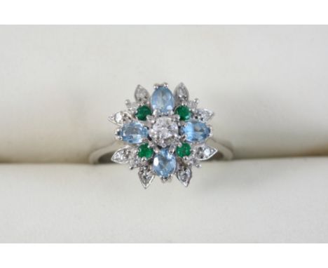 AN AQUAMARINE, EMERALD AND DIAMOND CLUSTER RING set with four oval-shaped aquamarines and with circular-cut emeralds and diam