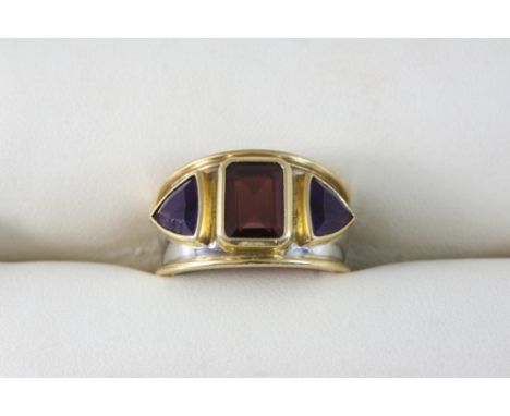 AN AMETHYST AND GARNET RING BY THEO FENNELL set with a rectangular-shaped garnet and two rounded triangular-shaped amethysts 