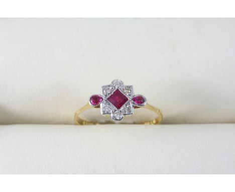 A RUBY AND DIAMOND RING set with a square-shaped ruby and two pear-shaped rubies within a surround of circular-cut diamonds, 