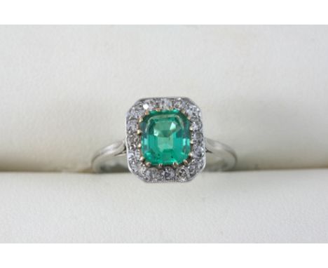 AN EMERALD AND DIAMOND CLUSTER RING the rounded rectangular-shaped emerald is set within a surround of old brilliant-cut diam